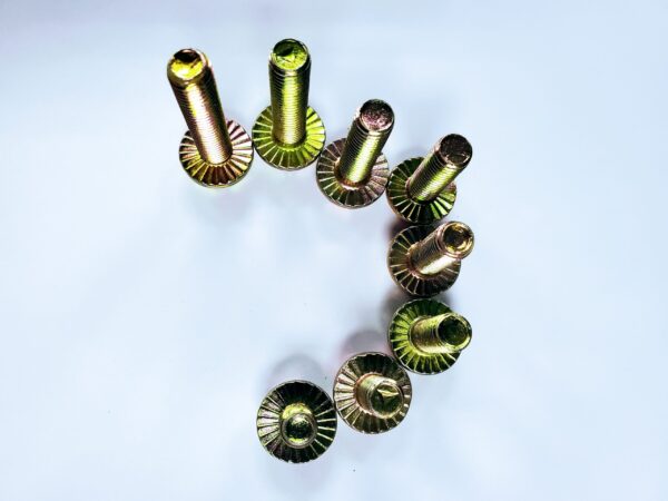 A group of metal nuts and bolts on top of a table.