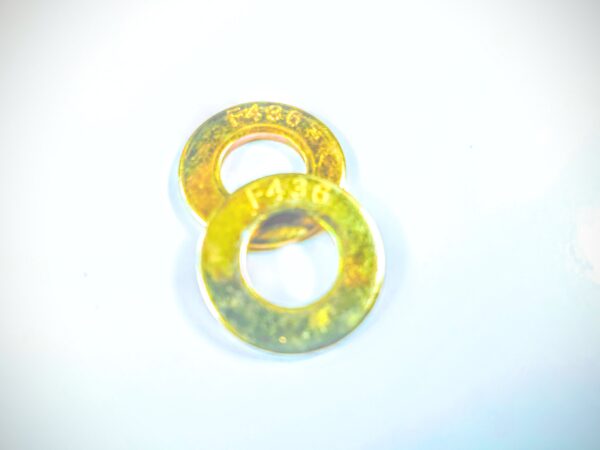 A pair of yellow washers sitting on top of a white surface.