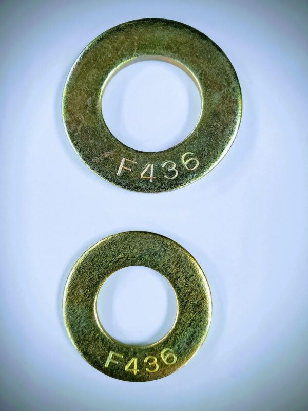 A pair of brass washers with numbers on them.